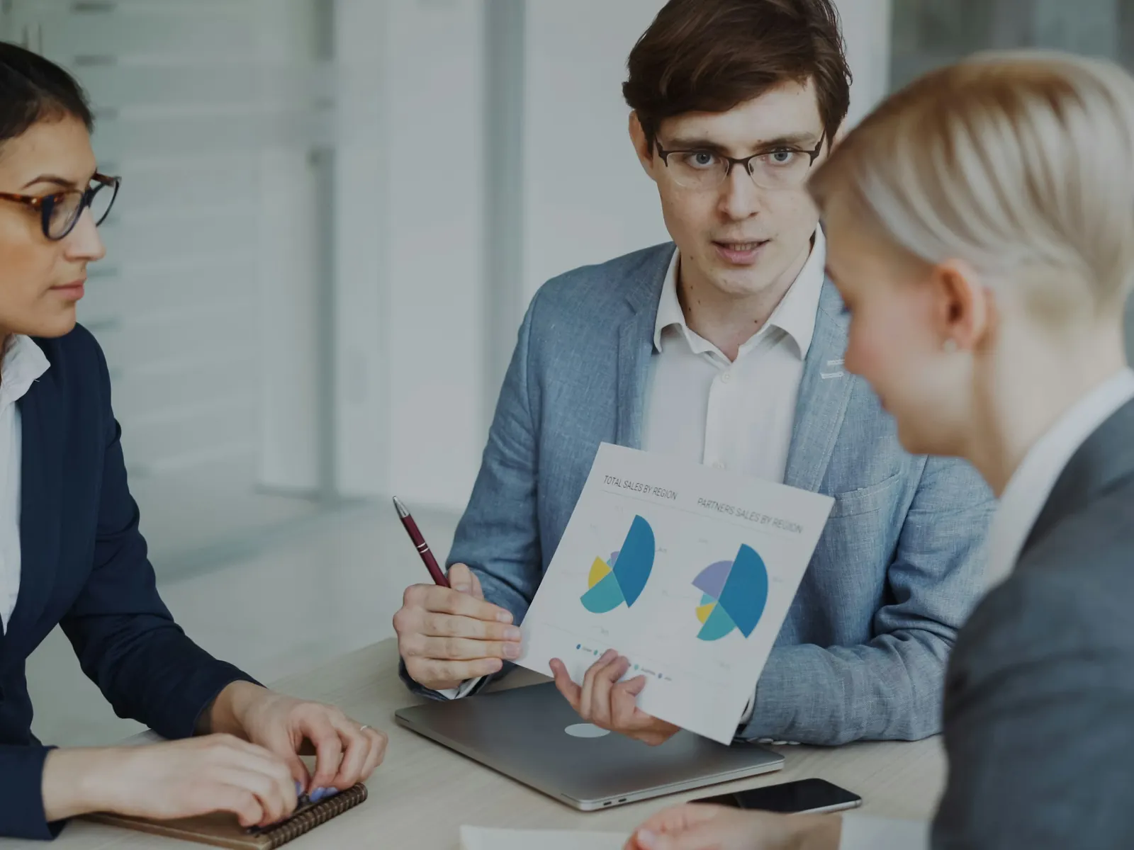 Finance professionals reviewing printed charts in a meeting