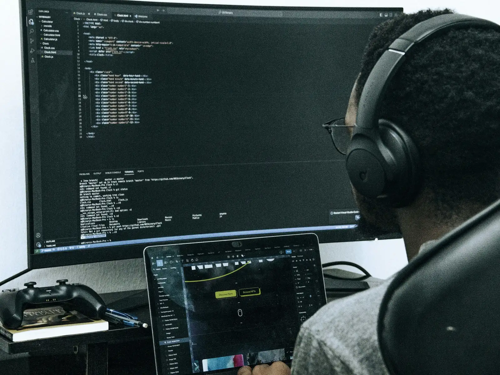 Developer in headphones working through code on a large monitor