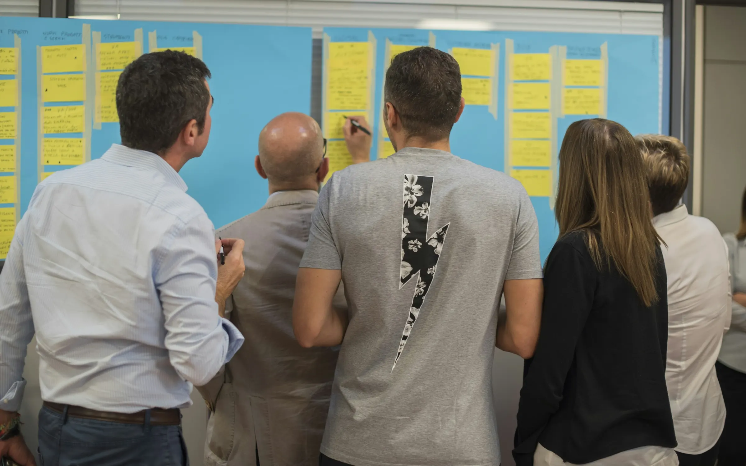 Workshop group mapping ideas on a wall of sticky notes